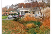 Front exterior of a single-story brick health care building with a covered entrance, parked cars, and autumn landscaping.