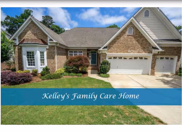 Front exterior of a brick house with a three-car garage and a blue banner reading "Kelley's Family Care Home".