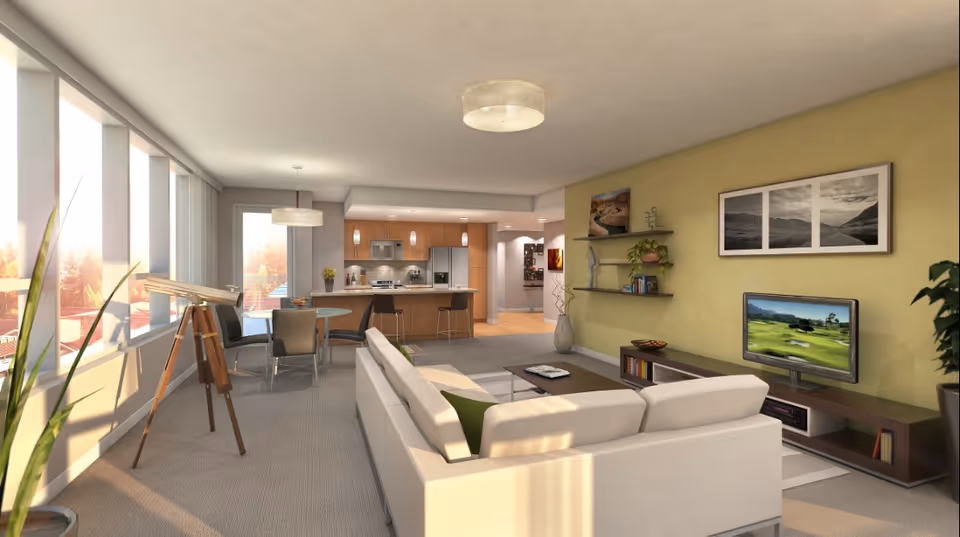 A bright and modern open-concept living area featuring a white sectional sofa facing a flat-screen TV mounted on a low wooden media console. The room has large windows letting in natural light, a telescope near the windows, a round glass dining table with four chairs, and a kitchen with wooden cabinets and stainless steel appliances in the background. The walls are painted light green and decorated with framed pictures and shelves with plants and books.