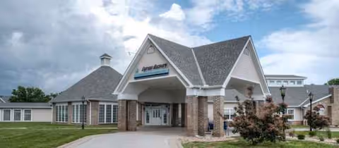 Elegant senior living campus entrance with brick pillars and a covered porte-cochère.