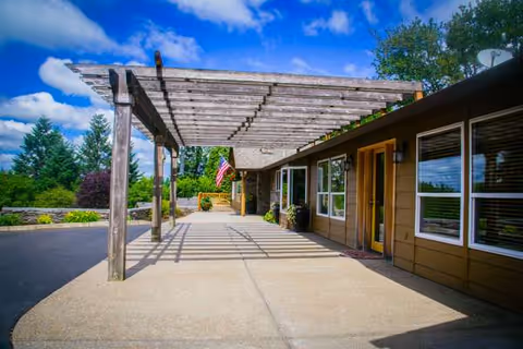 Exterior view of Canyon Creek AFH with a wooden pergola walkway and entrance.