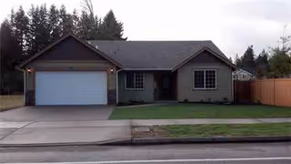Single-story house with a two-car garage, front lawn, and driveway.