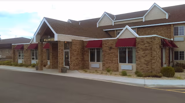 Exterior view of Harmony View Assisted Living with brick facade and red awnings.