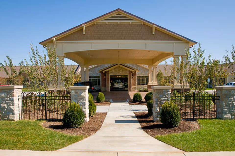 Front entrance of the Life Care Center showing a covered porte-cochere, central walkway, and landscaped grounds.