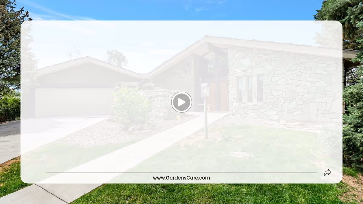 Exterior view of a single-story stone house with a driveway, garage, and a walkway leading to the front door, surrounded by green grass and trees under a clear blue sky.