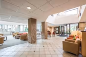 Bright, open lobby with tiled floors, seating areas, and glass entrance at Heritage Villas.