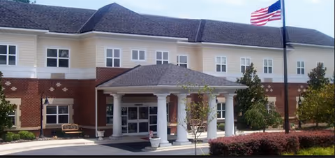 Exterior front view of The Living Center of Concord with entrance portico and flag