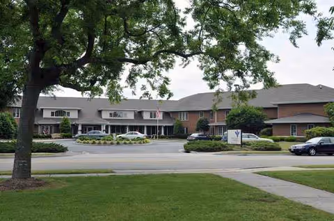 Exterior view of Karolwood Gardens Portsmouth with cars and manicured entrance.