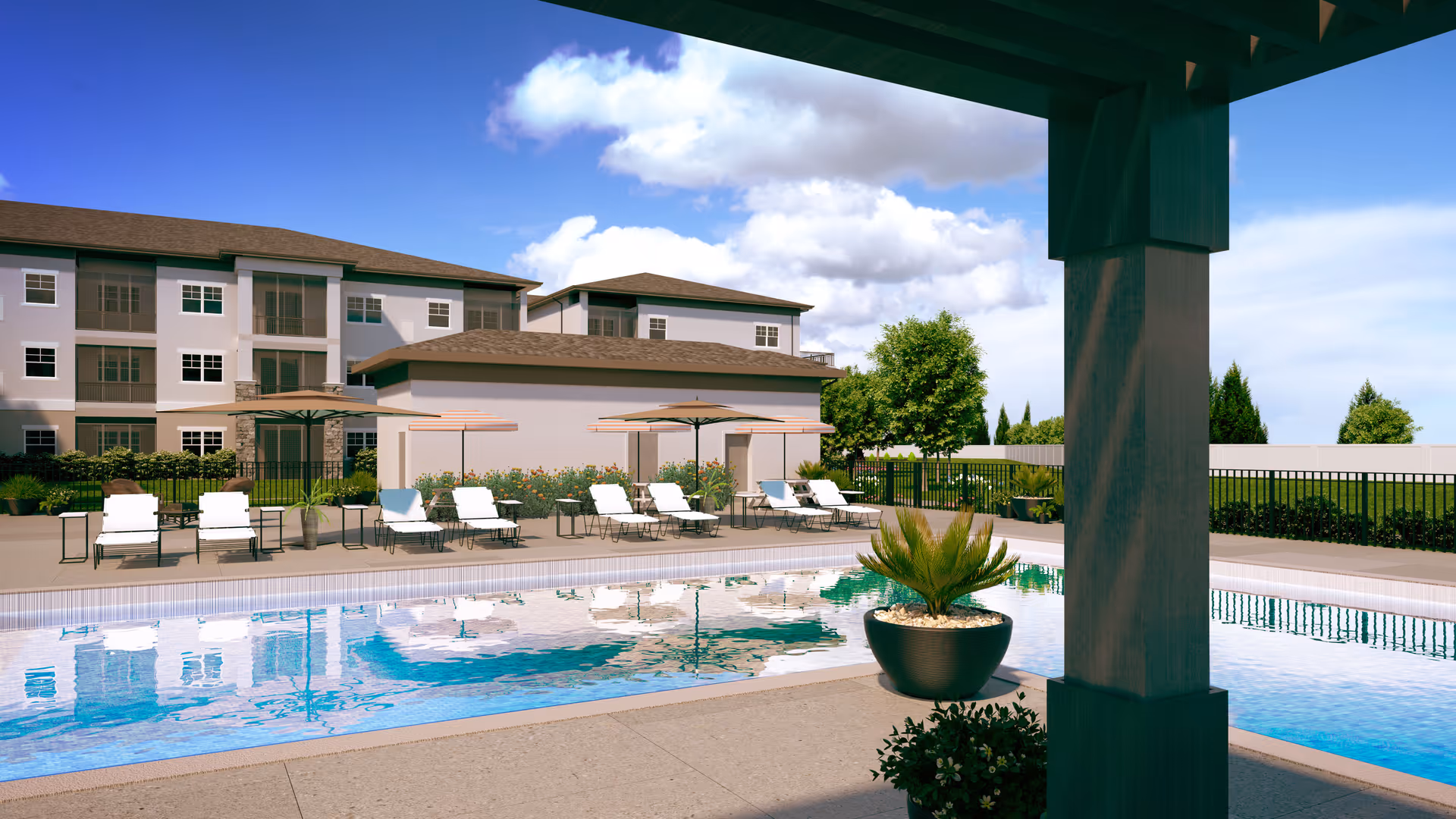 Outdoor swimming pool area at Highpoint at Stonecrest with lounge chairs and umbrellas along the poolside, surrounded by a fence and greenery, with a multi-story residential building in the background under a partly cloudy blue sky.