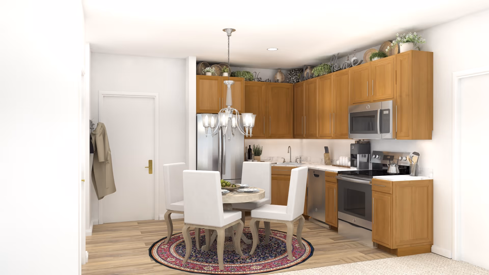Bright kitchen with wooden cabinets, stainless steel appliances and a round dining table with four upholstered chairs on a patterned rug.