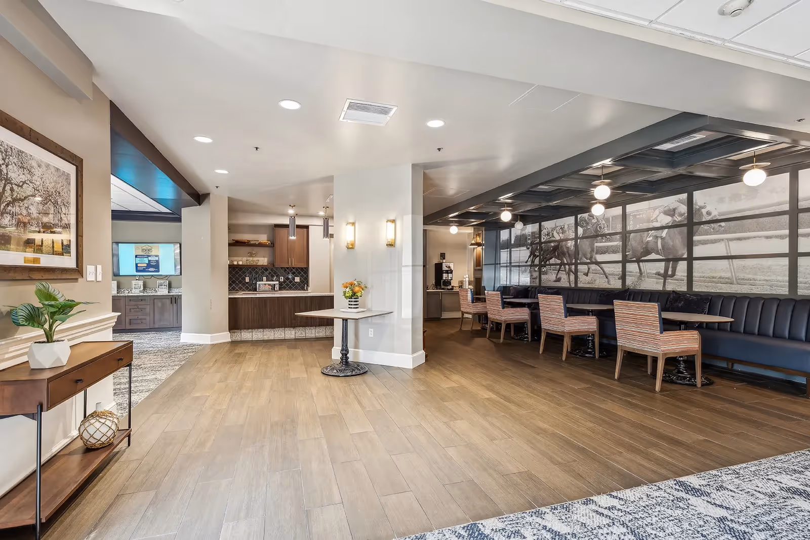 Spacious communal dining and lounge area with tables, banquette seating, a service counter, and large wall artwork.