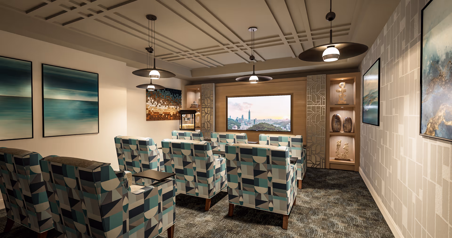 A cozy media room with patterned armchairs arranged in rows facing a large flat-screen TV mounted on the wall. The room features modern pendant lights hanging from a decorative ceiling, abstract artwork on the walls, and built-in shelves with decorative items. The carpet has a textured pattern, and the overall color scheme includes shades of blue, beige, and brown.