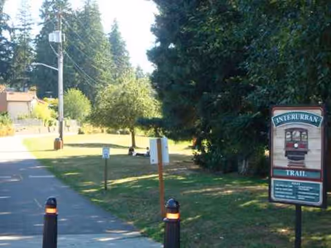 Outdoor park path with bollards and a sign for Interurban Trail