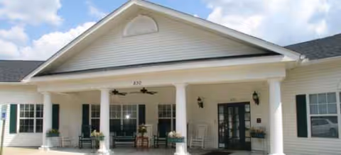 Exterior view of Brookdale Smithfield's front entrance with white columns and seating.