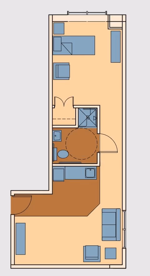 Floor plan of a senior living facility unit showing a layout with a living area, kitchen, bathroom, and bedroom space. The living area includes seating furniture, the kitchen has a sink and counter space, the bathroom contains a toilet and shower, and the bedroom area has a bed and additional furniture.