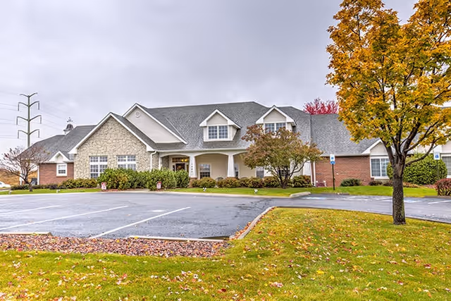 Exterior view of Brookdale Briargate senior living facility with parking and autumn trees.