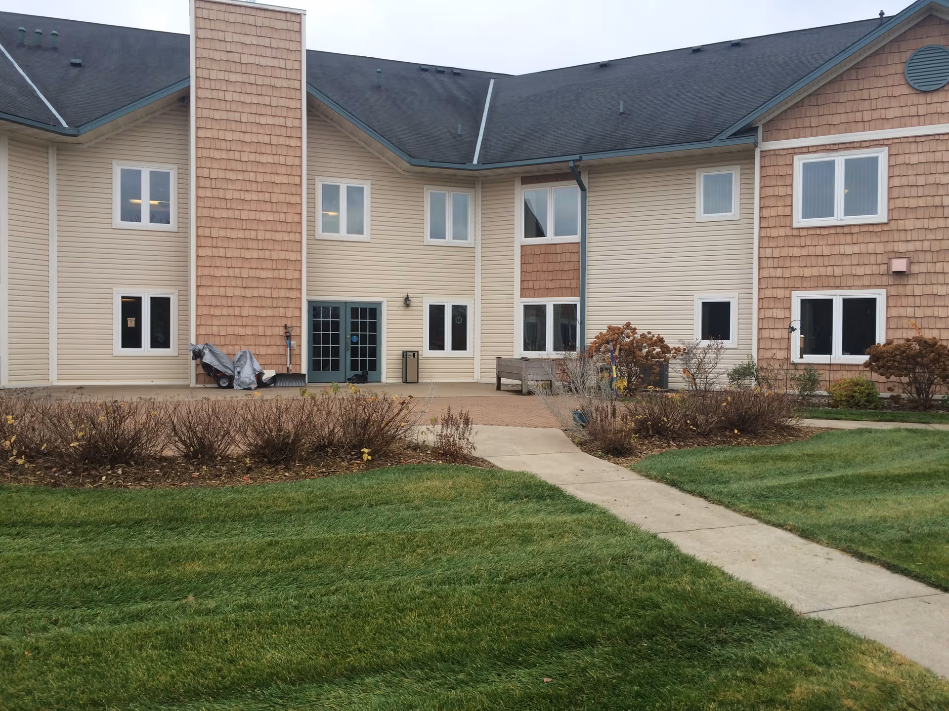 Exterior view of Grace Lodge Assisted Living building with a walkway and landscaped lawn.