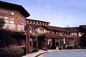 Exterior view of a senior living facility building at dusk with multiple windows, balconies, and a covered entrance area.