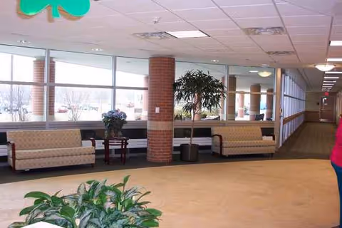 Interior lobby of Martha T Berry Medical Care Facility with sofas, plants, and windows.