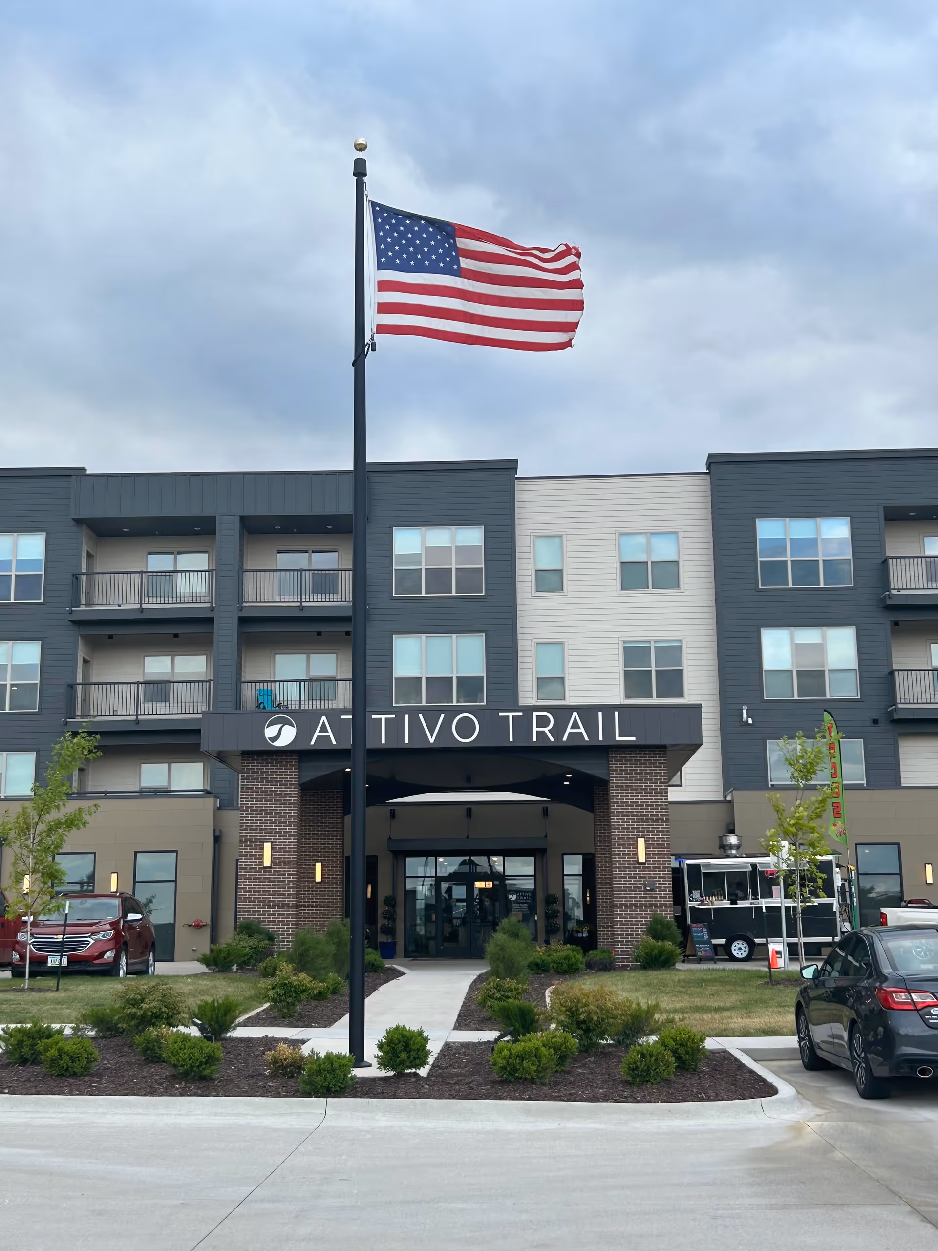 Front entrance of the Attivo Trail building with an American flag flying on a flagpole in the driveway.