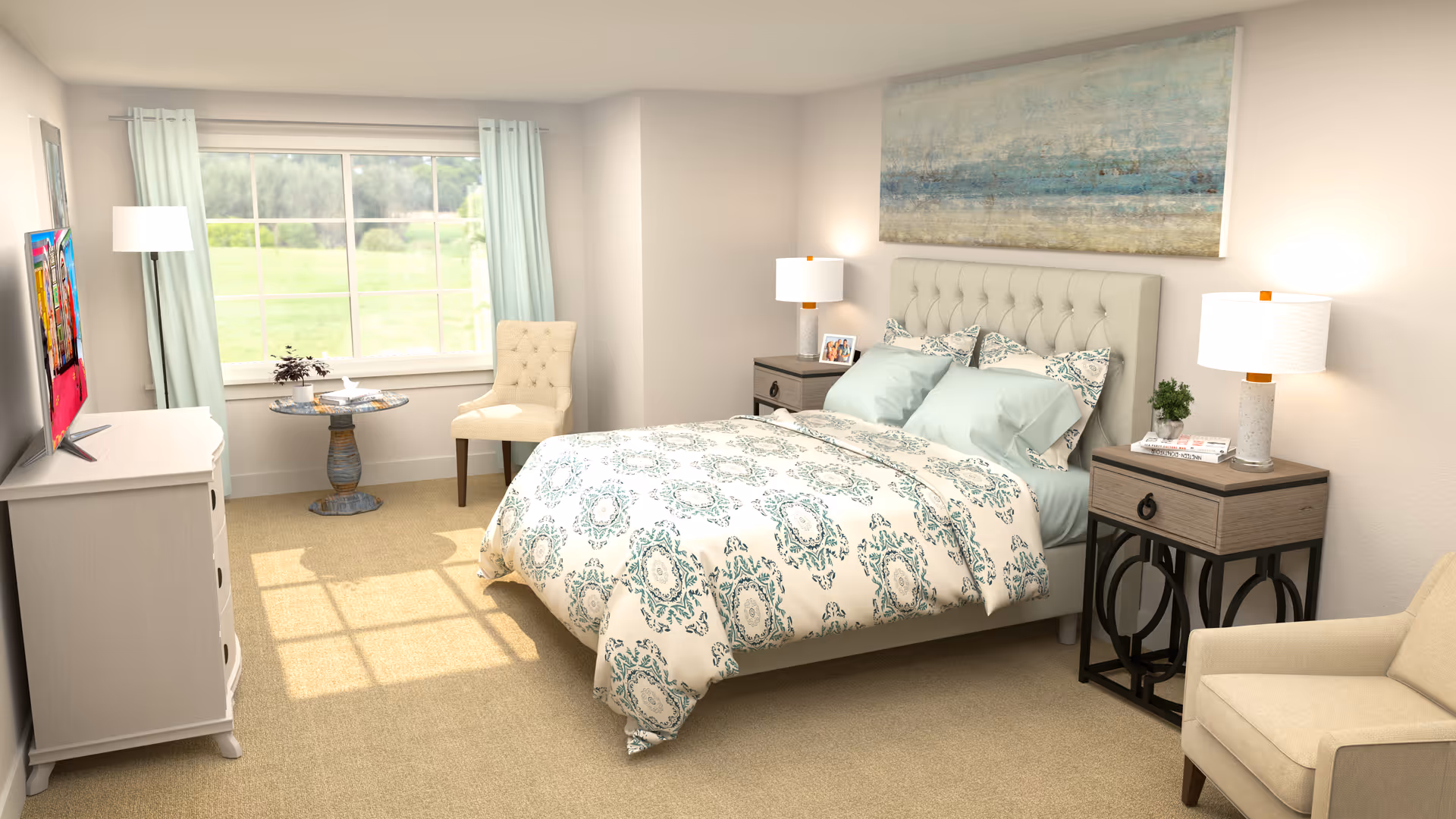 A bright and cozy bedroom with a large window letting in natural light. The room features a bed with a patterned comforter and multiple pillows, two bedside tables each with a lamp, a cushioned armchair, a small round table with a chair near the window, and a dresser with a flat-screen TV mounted above it. The walls are light-colored, and there is a large abstract painting above the bed.