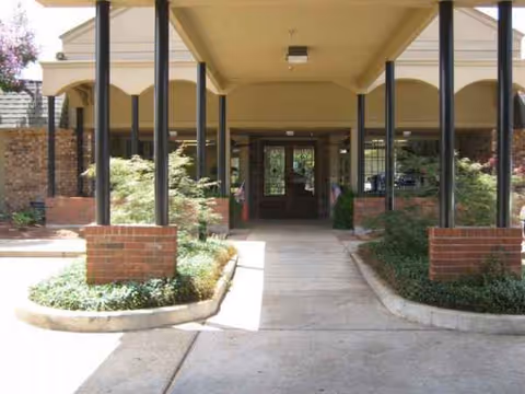 Covered walkway to the entrance of Matthews Memorial Health Care, with brick planters and columns.