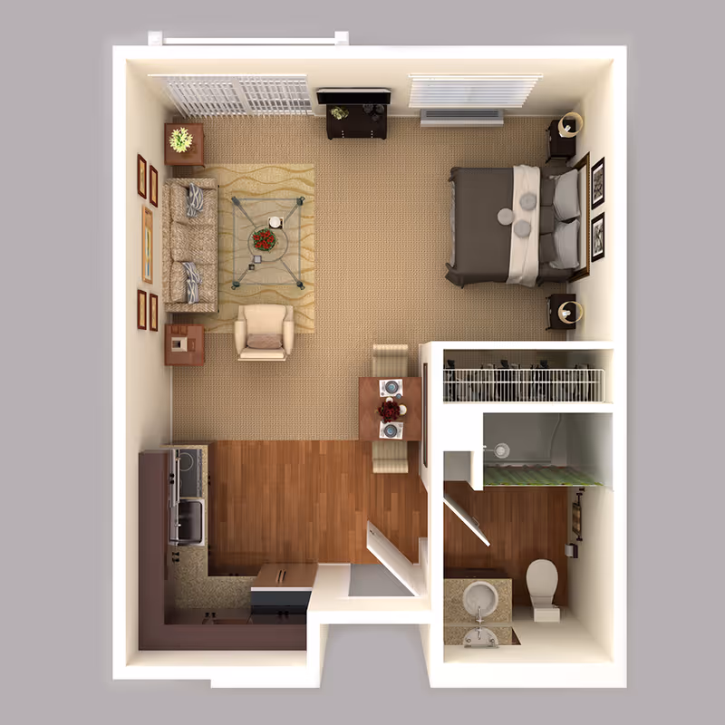 Top-down view of a senior living studio apartment floor plan featuring a combined living and sleeping area with a bed, sofa, armchair, coffee table, and TV stand. The kitchen area includes a sink, stove, and refrigerator. There is a small dining table with two chairs near the kitchen. The bathroom has a toilet, sink, and shower with a green curtain. The apartment has carpeted and wooden flooring sections.