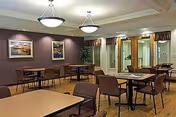 A cozy indoor dining area with multiple tables, chairs, and wall artworks.