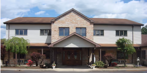 Front view of a two-story senior living facility with brick-and-siding exterior.
