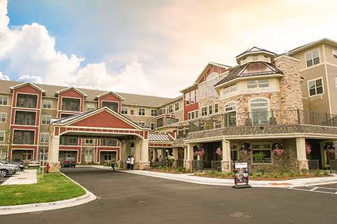 Exterior view of New Perspective Senior Living Brookfield with entrance canopy and parked cars.