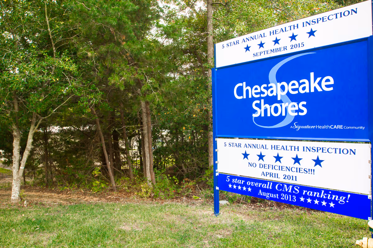 Outdoor sign for Chesapeake Shores Nursing Center surrounded by trees and grass, displaying 5-star annual health inspection ratings from September 2015 and April 2011, and a 5-star overall CMS ranking from August 2013.