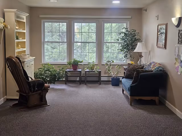 Cozy living room in Prairie View Senior Living with sofa, plants, and large windows.