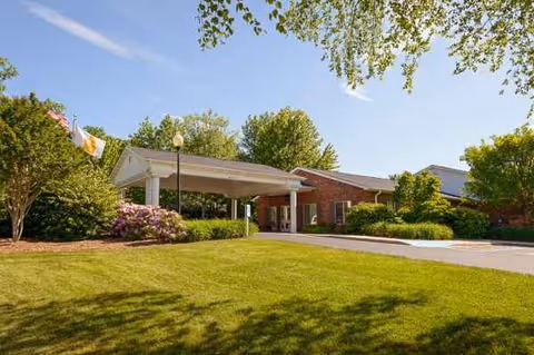 Front view of Life Care Center of Hendersonville entrance with a covered porte-cochere and lawn.