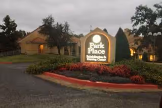 Exterior view of Park Place Nursing and Rehabilitation Center sign with building and landscaping.