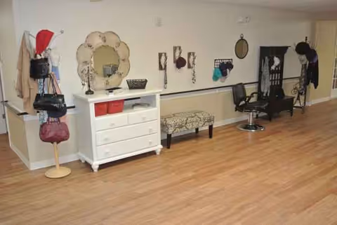Interior of a senior living facility salon area with dresser, mirror, bench, and styling chair
