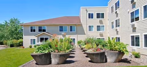 Exterior view of Brookdale Heritage Plaza with large planters along a pathway.