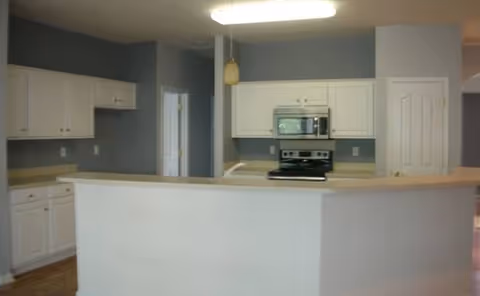Open kitchen with white cabinets, a breakfast bar, and stainless steel appliances.