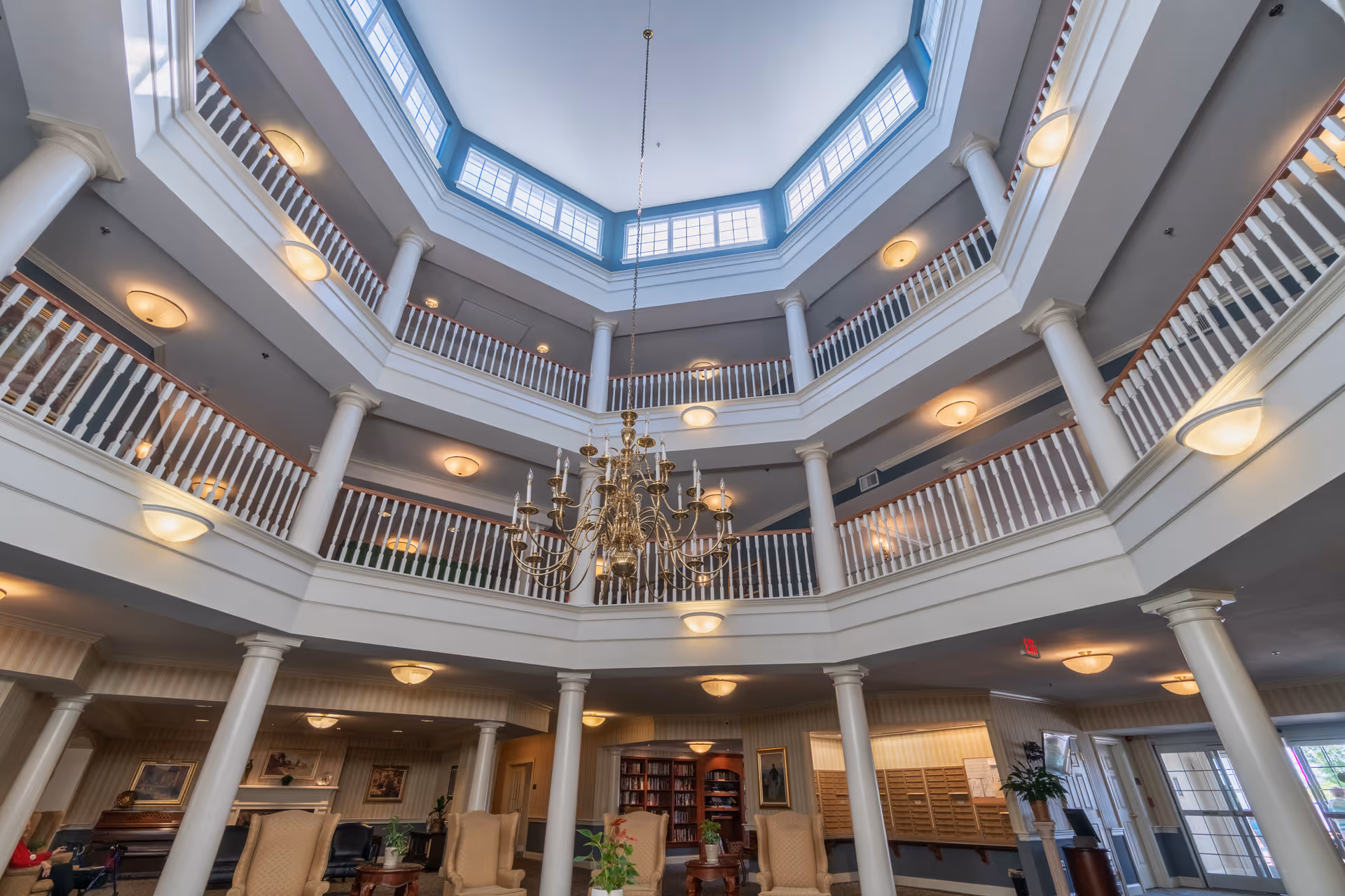 Atrium-style interior lobby with a central chandelier, multi-level balconies and a skylight.