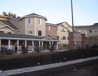 Exterior view of Rose of East Des Moines senior living facility with a porch.