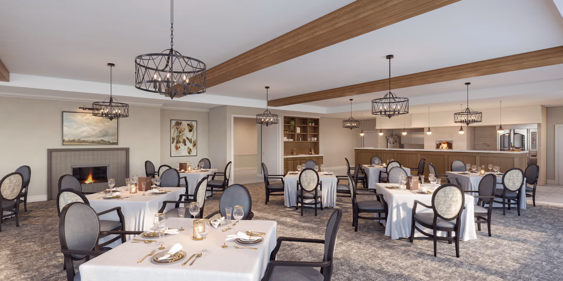 Spacious elegant dining room with round tables set with white tablecloths, upholstered chairs, chandeliers, a fireplace, and an open kitchen area.