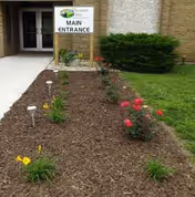 Nursing home main entrance with a mulched garden bed.