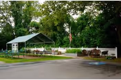 Outdoor seating area at Lakeview House with a green canopy and white fence.