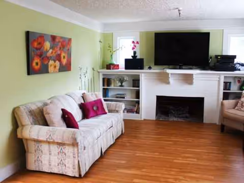 Bright living room with fireplace, TV, and comfortable sofas.