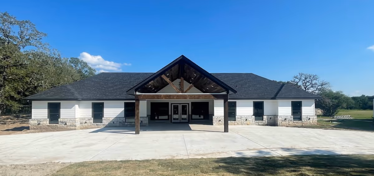 A single-story Peach Creek Assisted Living building with a wide entrance and concrete driveway.