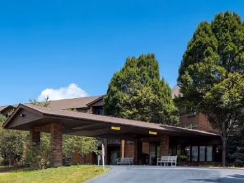 Exterior view of Autumn Ridge Residences showing brick entrance and covered driveway.