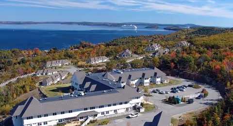 Aerial view of Birch Bay Retirement Village campus with multiple buildings, parking, and shoreline.