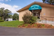 Exterior view of Kiowa Hills Health and Rehabilitation, a beige building with a ramp and landscaping.