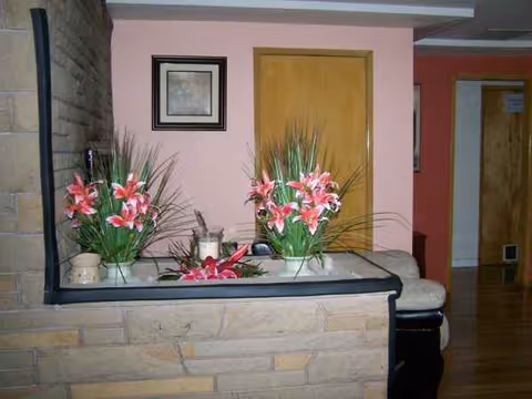 Interior lobby with pink wall, stone counter, and floral arrangements.