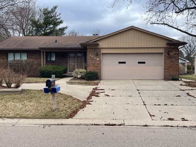 Front view of a single-story brick home with a two-car garage and driveway