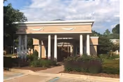 The Village of Heather Hills entrance with tall white columns and a beige facade.
